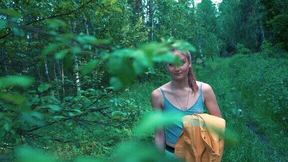 美丽的少女独自走在茂密的森林里的一条小路上动作缓慢