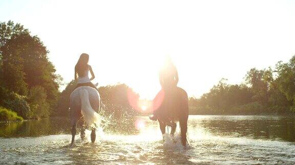 特写:两个年轻的女孩在强壮的马骑马微笑和交谈