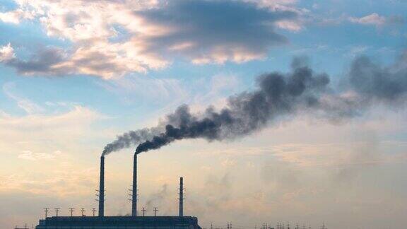 火力发电厂的高管与黑烟向上移动污染大气的特写以化石燃料生产电能