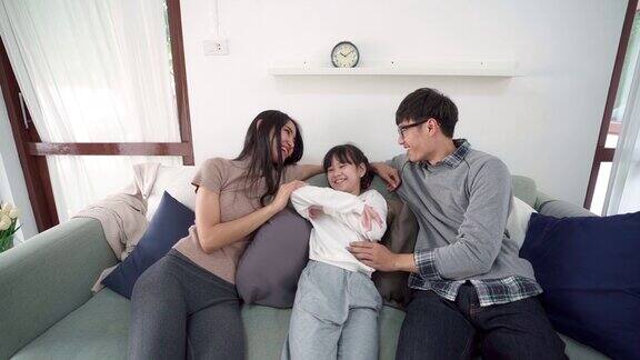 FHD慢镜头:幸福的亚洲家庭坐在沙发上互相拥抱家庭和幸福结合