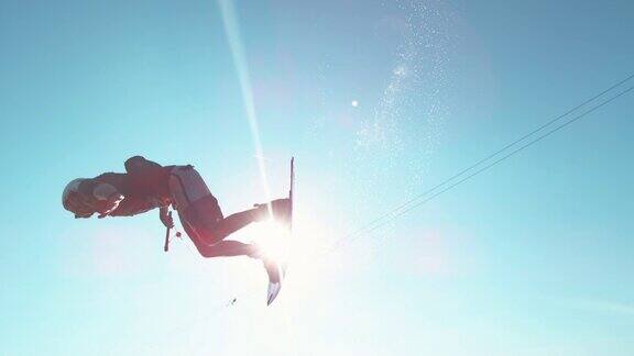镜头光晕:快乐的wakesurfer在飞过镜头时做了一个很酷的翻转戏法