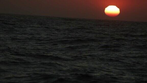 从一艘船的舷窗望去是平静的日落的海面