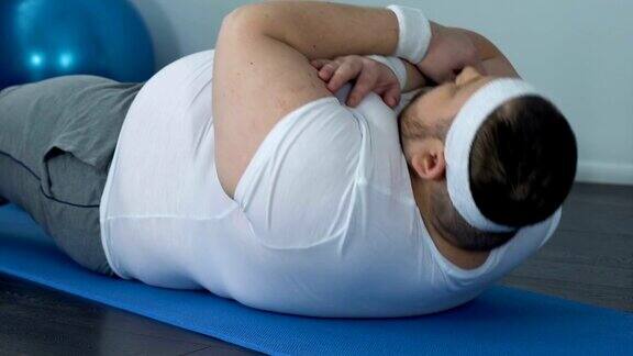 胖男人带着胖乎乎的肚子在家健身课上做仰卧起坐