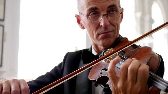 一幅小提琴手的肖像一个戴眼镜的老人在拉木小提琴