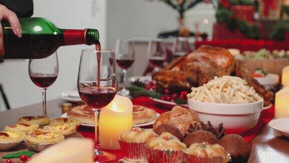 将红酒倒入餐桌上的玻璃杯里庆祝圣诞节
