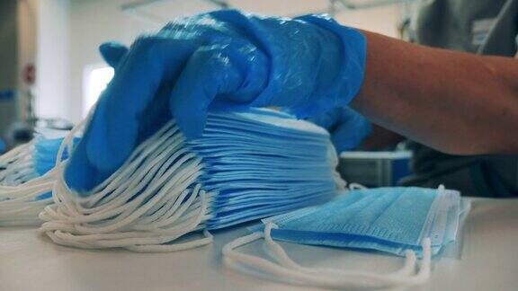 戴着手套的工人正在堆放医用口罩
