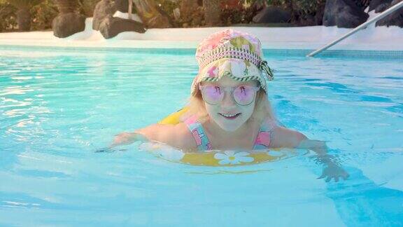 快乐的孩子在游泳池充气环在度假酒店水上乐园