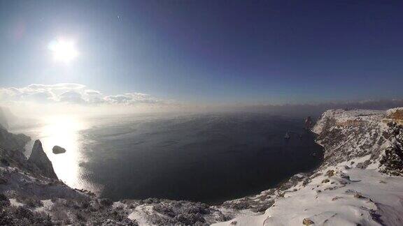 冰雪覆盖着海面上的岩石峭壁海湾的冬季景观雪下的杜松树寒假旅游休闲理念克里米亚塞瓦斯托波尔巴拉克拉瓦的佛罗伦特角