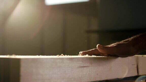 人的手在木板上产生灰尘的木屑颗粒