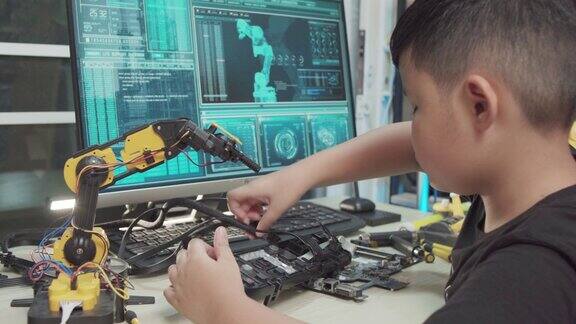教育主题:男孩学习如何在数字平板电脑上控制机器人手臂科学工程教育技术
