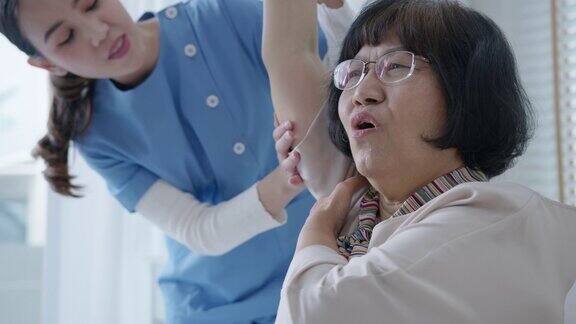 年轻的亚洲老年公民女性与搓洗护士物理治疗工作者在家里为年老的父母康复治疗服务按摩对老年人的护理对老年人疼痛关节的锻炼