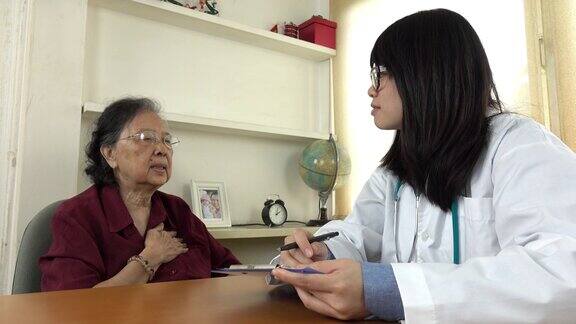 医生向一位老妇病人解释药物治疗
