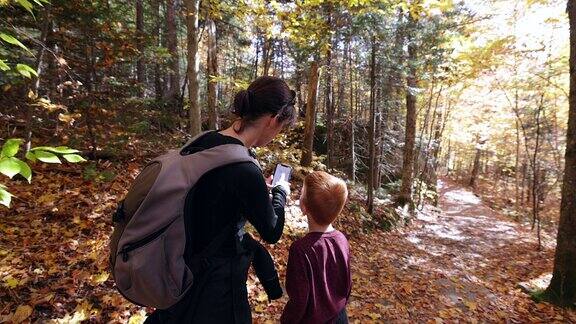 可爱的红发男孩和母亲在秋天徒步旅行在蒙特Tremblant国家公园魁北克加拿大