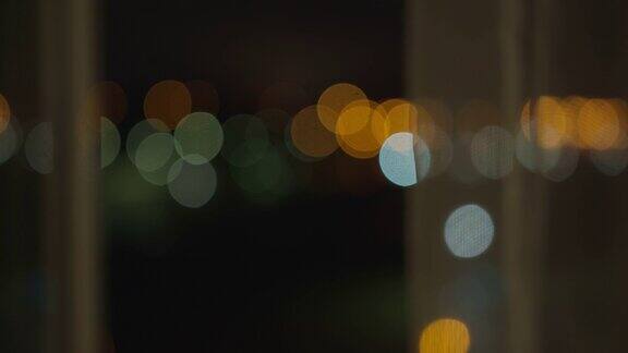 晚上打开窗户朦胧的城市灯光后面的薄纱