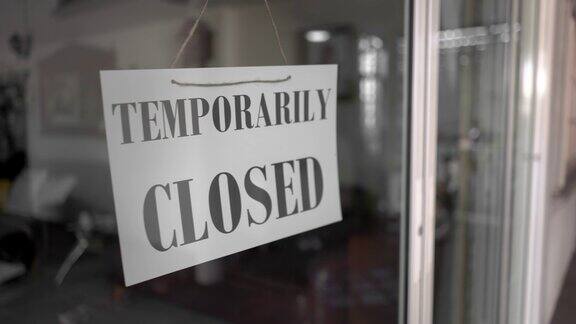 亚洲资深女性改变开放暂时关闭的店铺门上的标志