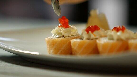 用勺子把鱼子酱放到寿司上