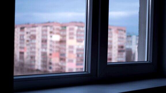 从白天到夜晚透过窗户看灯光在高层建筑的窗户