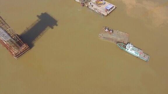 从河上的驳船起重机上一艘装载设备的小船从空中飞过