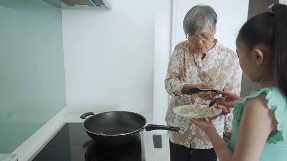 近距离的中国奶奶准备煮蒸汽中国饺子在烹饪锅在itchen