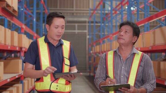 专业两名亚洲男性仓库工人手持平板电脑讨论盘点库存盘点货架库存在工厂或物流中心工作的员工