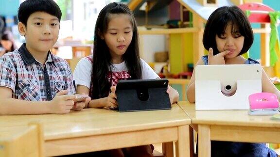 .亚洲孩子在玩平板电脑