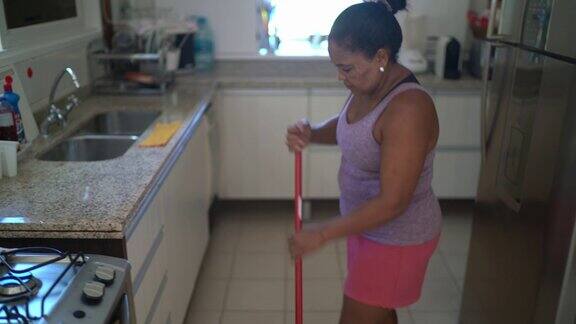 成熟的女人在家里扫地