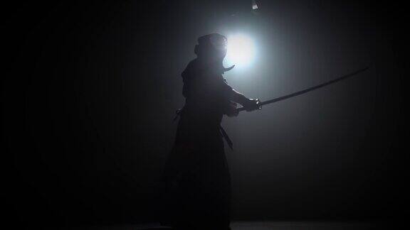 剪影剑道教练正在用武士刀练习武术慢动作