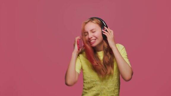 快乐的年轻女孩戴着耳机听音乐唱歌跳舞兴奋音乐应用广告
