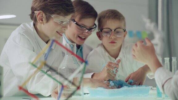 男孩们在实验室里玩得很开心用手制作动力沙