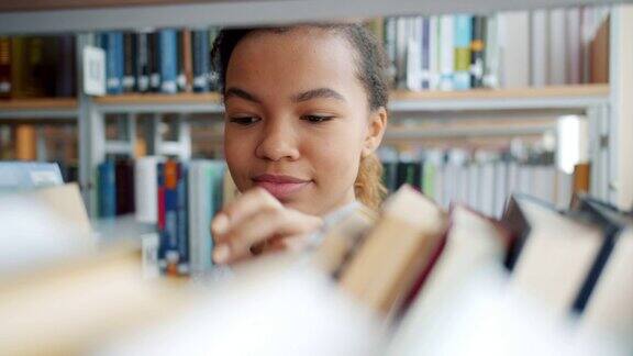 快活的非裔美国少年在学校图书馆选书