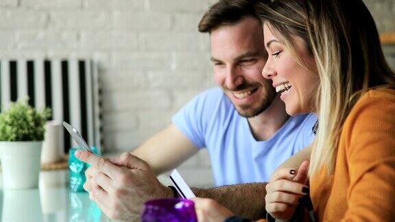 年轻快乐的夫妇在网上购物在家