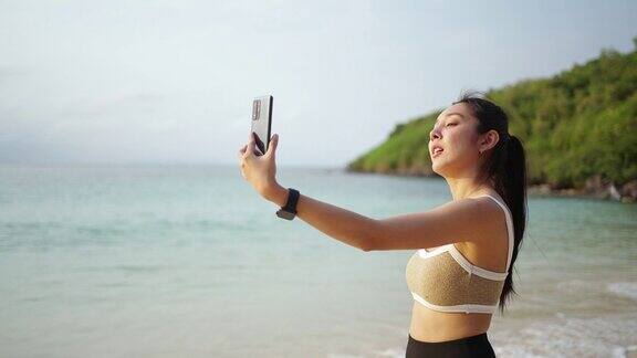 4K亚洲女子早上在海滩慢跑时用手机自拍