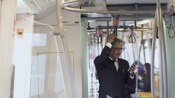 商人在地铁上使用智能手机