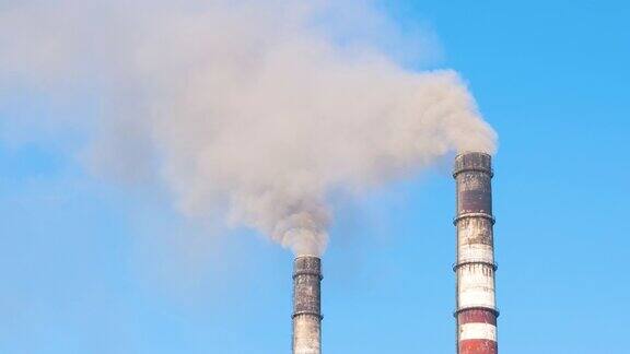 火力发电厂的高管与黑烟向上移动污染大气的特写以化石燃料生产电能