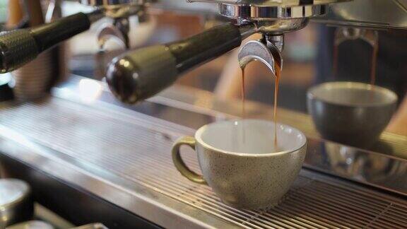 浓缩咖啡从咖啡机的双支架倒入杯子里