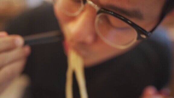 慢镜头亚洲男子吃日本拉面