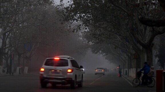 清晨的街道上行人和车辆被雾霾笼罩