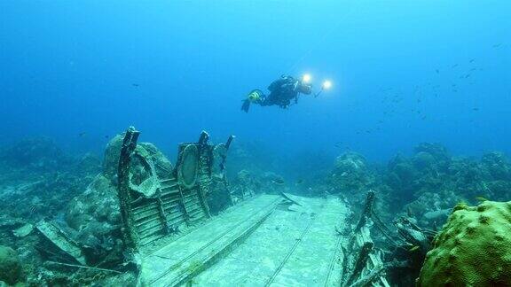 飞机残骸作为珊瑚礁的一部分在加勒比海库拉索岛周围的蓝色背景