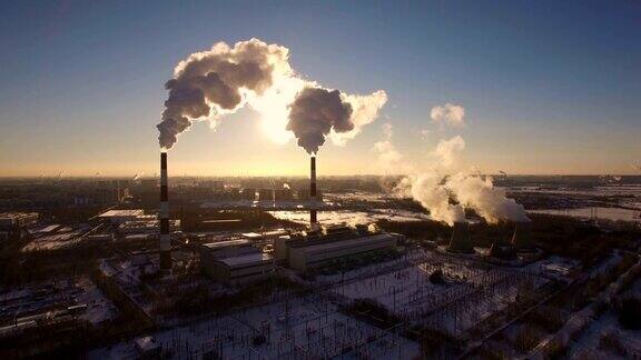 冒烟的烟囱发电厂的背景在冬天日落鸟瞰图