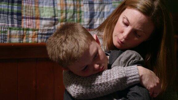 一位母亲安慰她的儿子他看起来很伤心