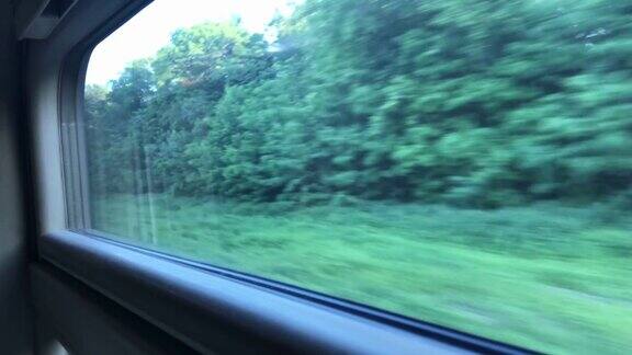 窗外的景色一列行驶的火车带着绿色的风景