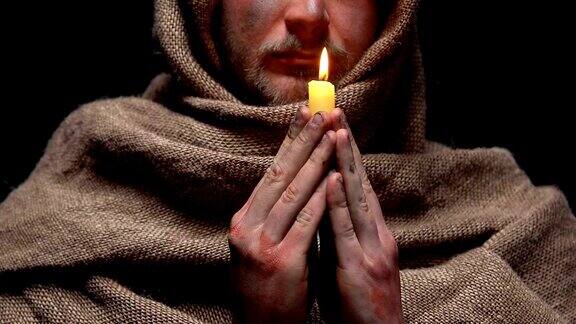 可怜的人手持燃烧的蜡烛祈祷祈求宽恕祈求希望