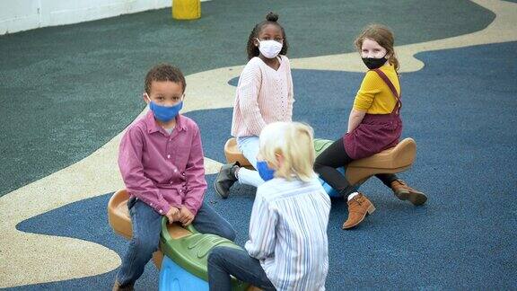儿童在操场上戴口罩COVID-19