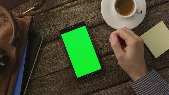 在家里的木桌上使用Android手机前视图因果的生活方式