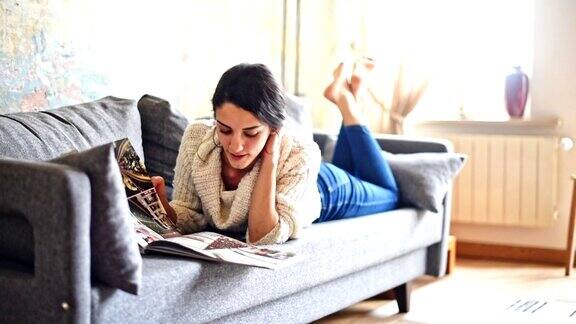 一个土耳其女人坐在沙发上看杂志