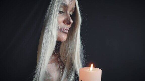 明亮的火光从燃烧的蜡烛女孩的白发在黑暗的房间