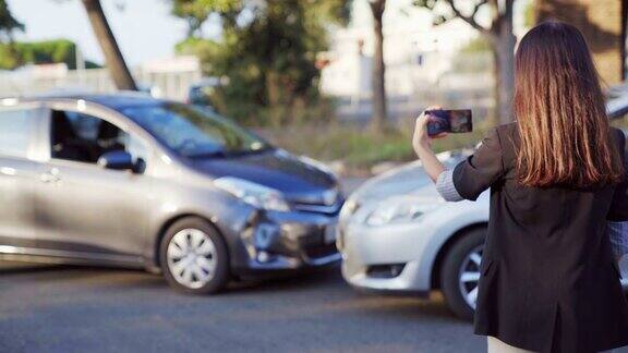 女性保险代理人用手机拍下了车祸的照片一名女性用智能手机记录汽车损坏情况4kUHD