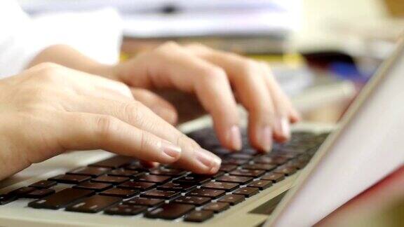 女人的手在笔记本电脑上打字