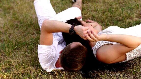 年轻的情侣在夏天躺在公园的草地上