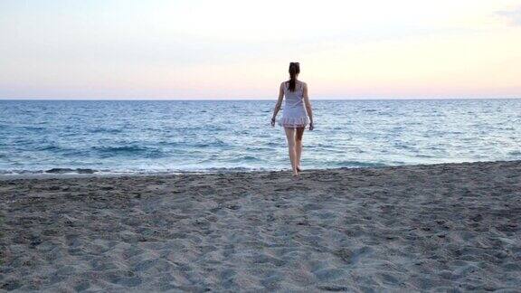 美丽的女孩独自在海滩上旅游